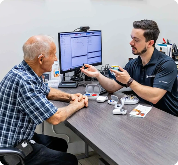A hearing specialist fitting a patient with hearing aids